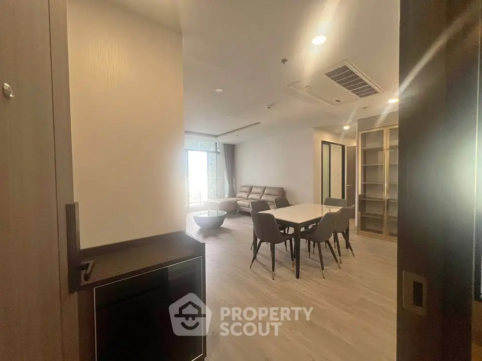 Spacious modern living room with dining area and stylish furniture in a well-lit apartment.