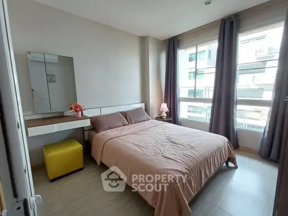 Cozy bedroom with large windows and modern decor in a stylish apartment.