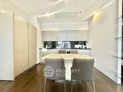 Modern kitchen with sleek cabinetry and dining area in contemporary apartment