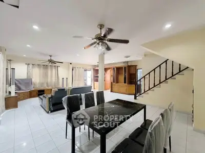 Spacious open-plan living and dining area with modern furnishings and ceiling fans.