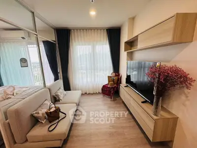 Modern living room with stylish decor and large window offering natural light.