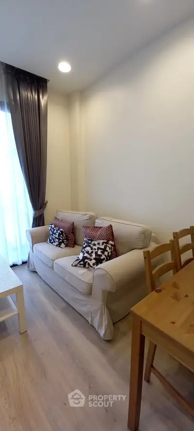 Cozy living room with elegant sofa and dining table, perfect for relaxation and entertaining.