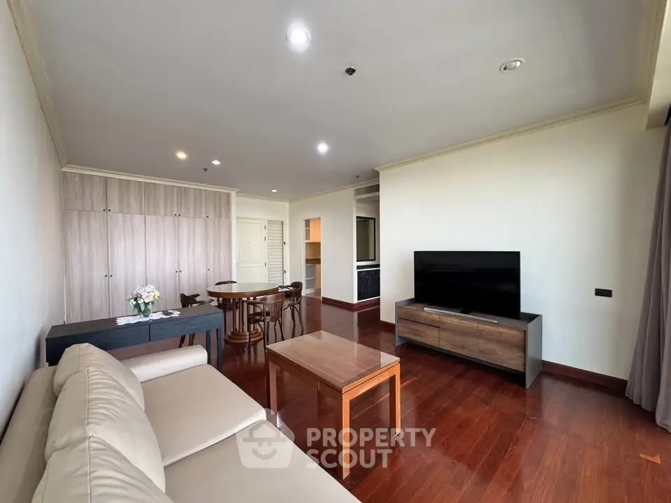 Spacious living room with modern furniture and wooden flooring in a stylish apartment.