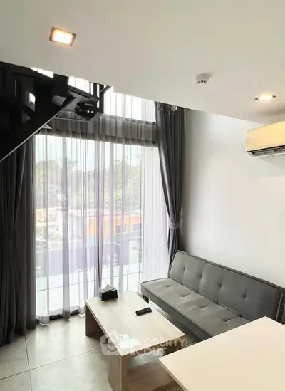 Modern living room with large windows and stylish furniture in a contemporary apartment.
