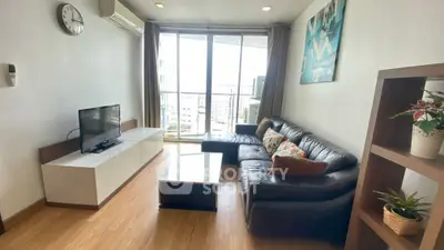 Modern living room with large windows and stylish decor in a high-rise apartment.