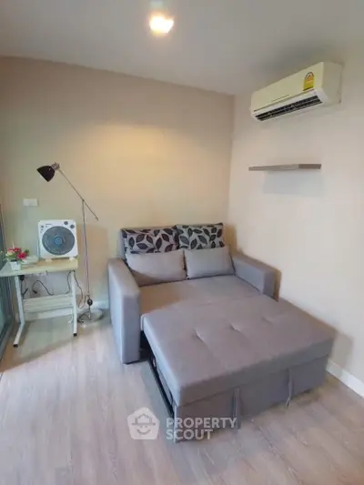 Cozy living room with modern sofa bed and air conditioning in a stylish apartment.