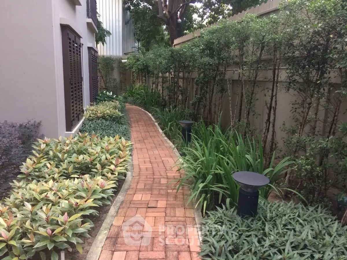 Charming garden pathway with lush greenery and elegant landscaping in a serene residential setting.