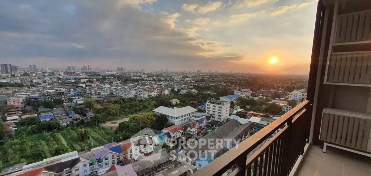 Stunning sunset view from a high-rise balcony overlooking a vibrant cityscape.