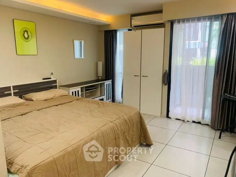Spacious bedroom with modern decor and large window for natural light.