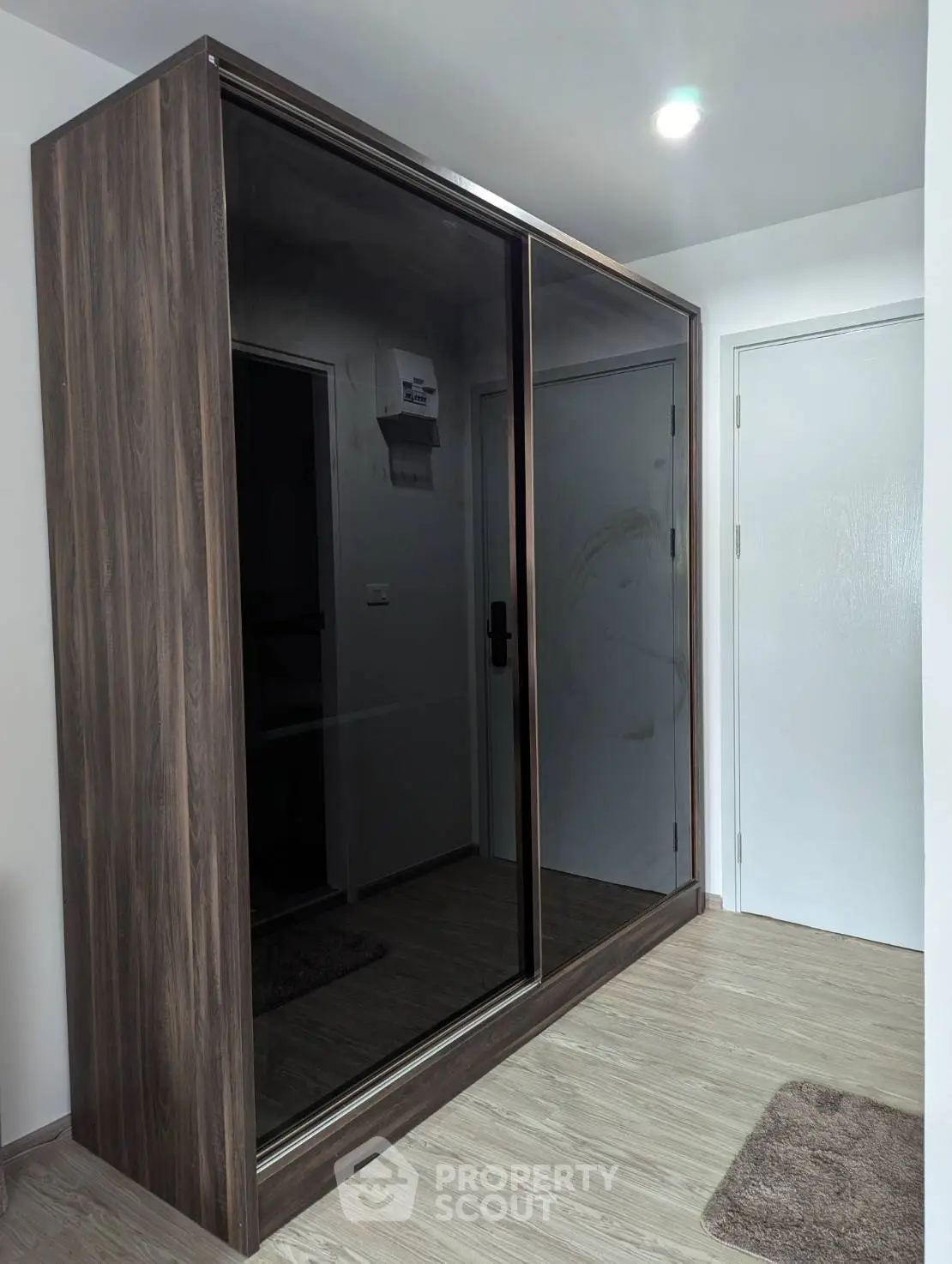 Modern wardrobe with sliding mirrored doors in a stylish interior space.