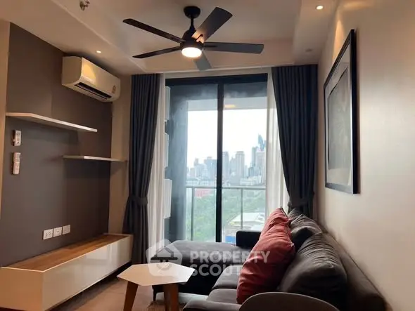 Modern living room with city view, featuring sleek furniture and ceiling fan.