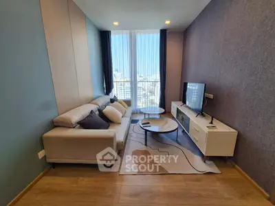 Modern living room with stylish furniture and large windows offering city views.