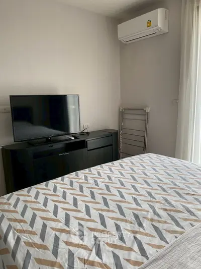 Cozy bedroom with modern TV and air conditioning, perfect for relaxation.