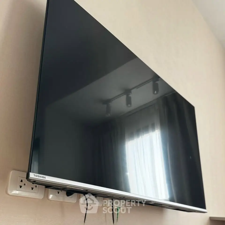 Modern living room with wall-mounted Toshiba TV and stylish lighting.