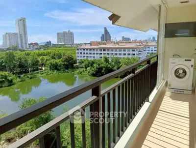 Spacious balcony with scenic city and lake view, featuring a washing machine for convenience.