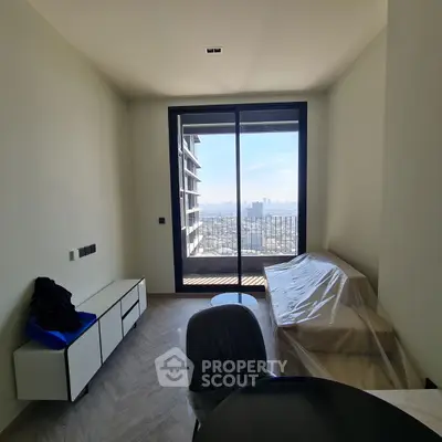 Modern living room with balcony and city view, minimalist furniture setup.