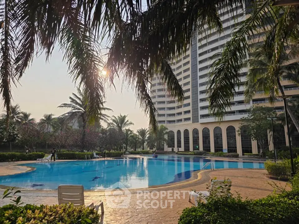 Luxurious residential building with a stunning pool and lush garden surroundings, perfect for relaxation and leisure.