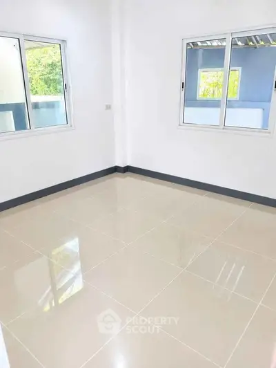 Bright empty room with large windows and glossy tiled floor, perfect for customization.