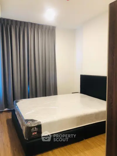 Modern bedroom with new mattress and elegant curtains in a cozy apartment.