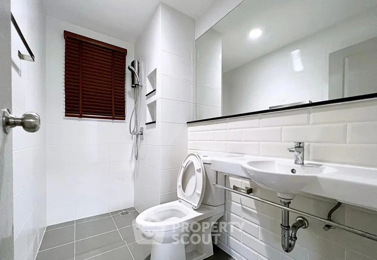 Modern bathroom with sleek white tiles and contemporary fixtures.