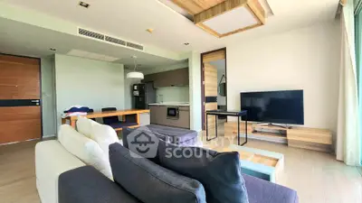 Modern living room with open kitchen and stylish furniture in a bright apartment.