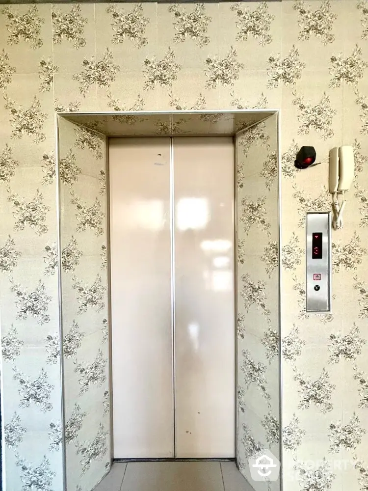 Elegant elevator with floral wallpaper in modern building