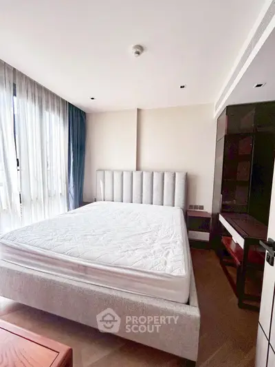 Spacious bedroom with modern design and large windows for natural light.