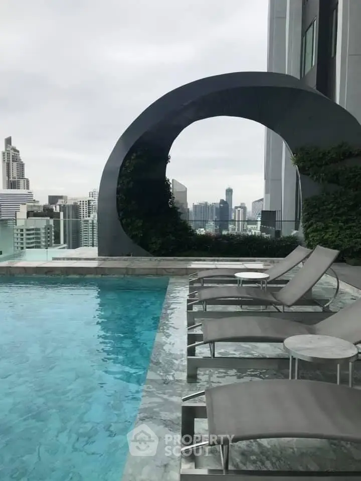 Luxurious rooftop pool with stunning city skyline views and modern lounge chairs.