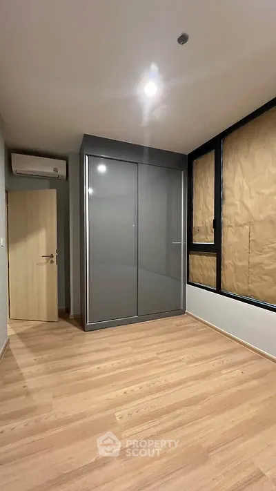 Modern empty bedroom with sleek wardrobe and wooden flooring