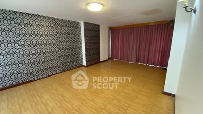 Spacious living room with elegant wallpaper and wooden flooring