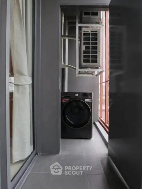 Compact balcony with washing machine and air conditioning unit in modern apartment.