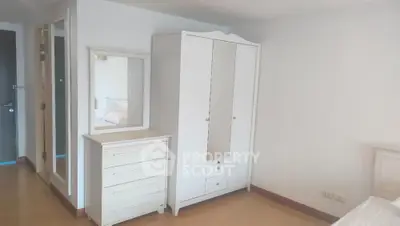 Spacious bedroom with white wardrobe and dresser in modern apartment