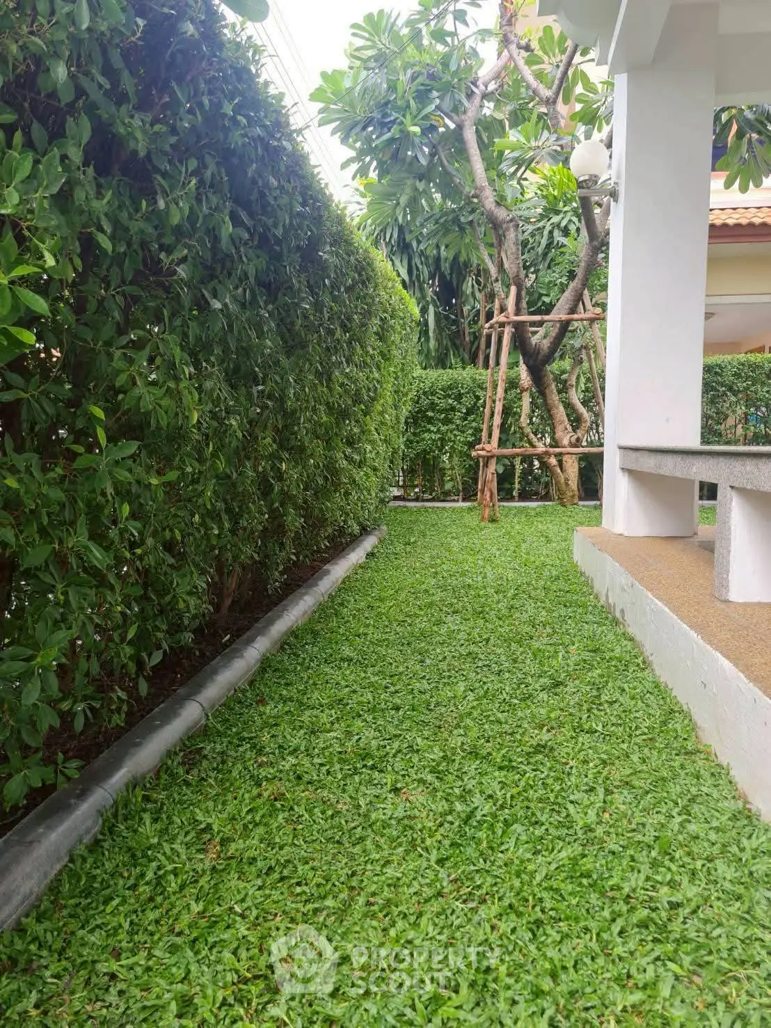 Charming garden pathway with lush greenery and manicured lawn, perfect for tranquil outdoor living.