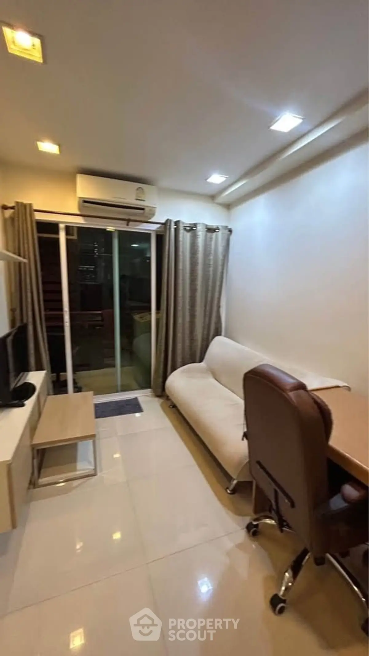 Cozy living room with modern furniture and sliding glass doors to balcony.