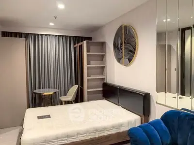 Modern bedroom with stylish decor, featuring a comfortable bed, elegant seating, and contemporary wall art.