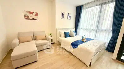 Modern bedroom with cozy sofa and large window, featuring elegant decor and natural light.