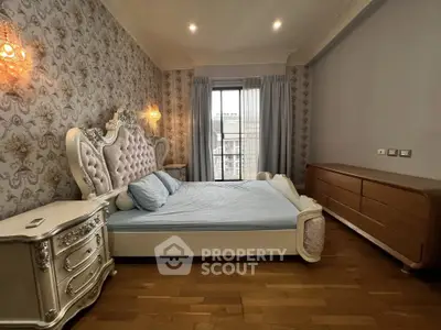 Luxurious bedroom with elegant decor and large window offering natural light.