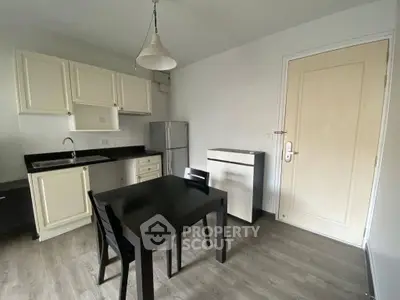 Cozy kitchen with dining area, featuring modern appliances and sleek cabinetry.