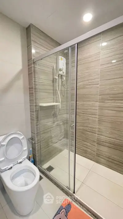 Modern bathroom with glass shower enclosure and sleek tile design.