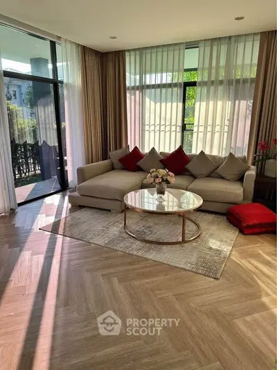 Spacious living room with elegant decor and large windows offering abundant natural light.