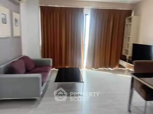 Modern living room with sleek furniture and large window with curtains