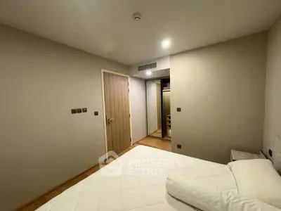 Cozy bedroom with modern design and wooden accents, featuring a comfortable bed and built-in wardrobe.