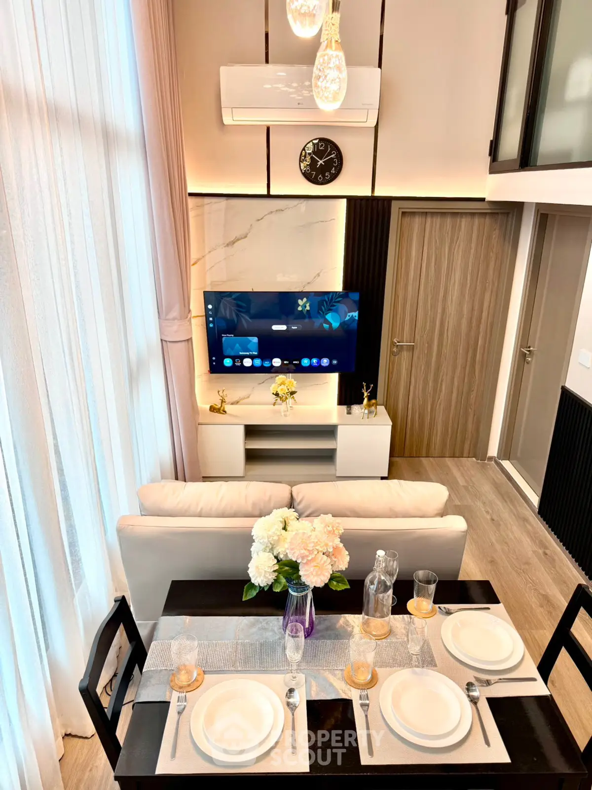 Modern living room with high ceilings, elegant decor, and dining area in a stylish apartment.