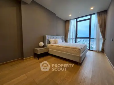 Luxurious bedroom with city view, featuring elegant bed and floor-to-ceiling windows.