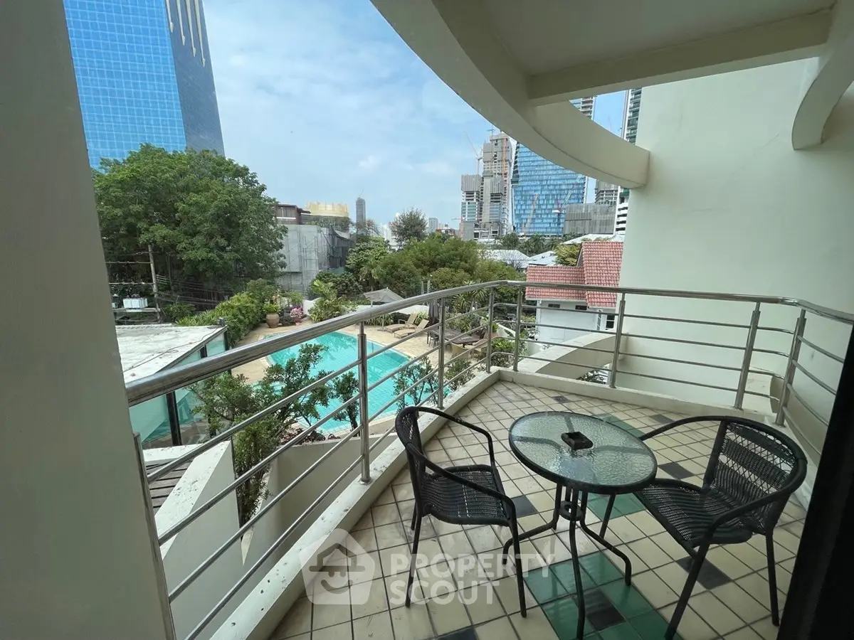 Charming balcony with city view overlooking pool, perfect for relaxation and urban living.