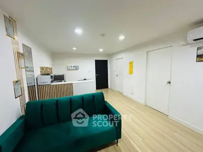 Modern living room with stylish green sofa and sleek wooden flooring