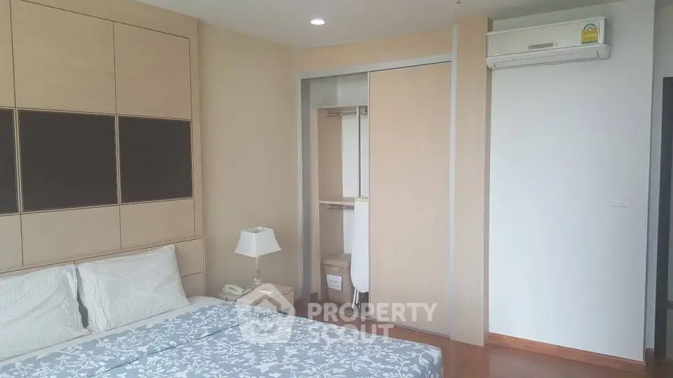Modern bedroom with built-in closet and air conditioning in a stylish apartment.