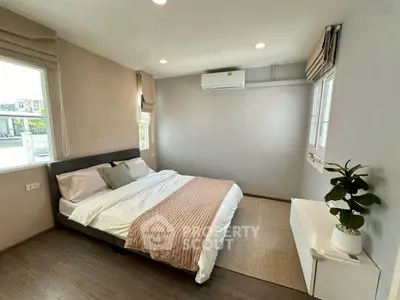 Spacious bedroom with modern decor and natural light, featuring a comfortable bed and stylish furnishings.