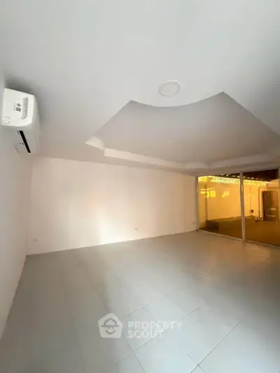 Spacious unfurnished room with modern ceiling design and large window for natural light.