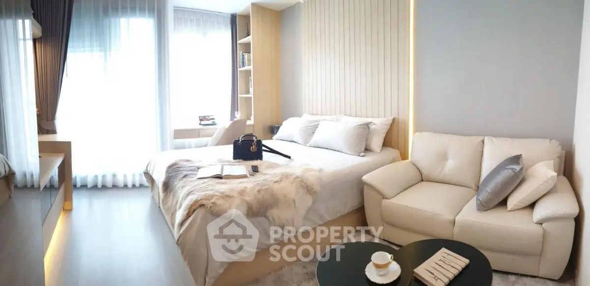 Luxurious modern bedroom with elegant decor and cozy seating area, perfect for relaxation and comfort.
